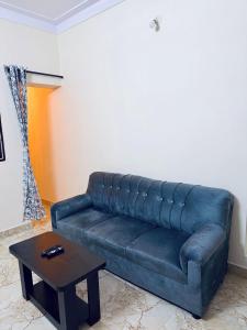 a leather couch in a living room with a table at Wee Homes in Bangalore +2 photos
