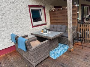 a patio with wicker chairs and a table on a deck at Waldbaden in Fürthen