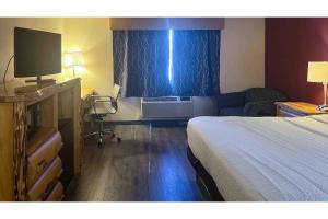 a hotel room with a bedroom with a bed and a television at Studio 6 Suites Butte MT I-90 I-15 in Butte