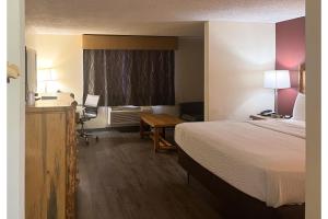 a hotel room with a bed and a desk at Studio 6 Suites Butte MT I-90 I-15 in Butte +16 photos