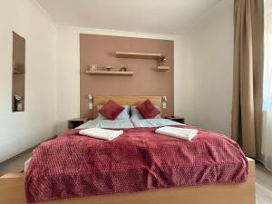 a bedroom with a large bed with a red blanket at Balaton Bloom 24 in Siófok