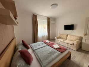 a small room with a bed and a couch at Balaton Bloom 24 in Siófok +3 photos