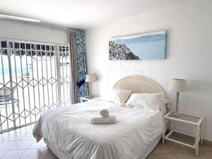 a bedroom with a white bed and a large window at Club 10 Management in Ballito +51 photos