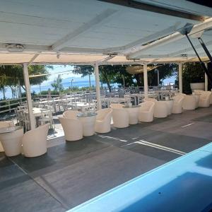 a row of white tables and chairs under a pavilion at Casa Vacanza Colletta - appartamenti e lido in Casteldaccia