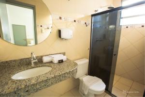 a bathroom with a sink and a toilet and a mirror at Rede Andrade Itabuna in Itabuna