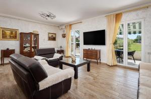 a living room with a couch and a tv at Villa MontAnja in Herceg-Novi