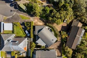 an overhead view of roofs of houses and trees at Ocean view Designer Standalone Villa Big Deck in Auckland