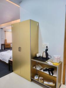 a large gold cabinet in a room with a bed at Nirvana Stay & Gaming Zone in Bhadarwāh