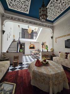 a large living room with a table and a staircase at Riad Anbar in Marrakesh +104 photos