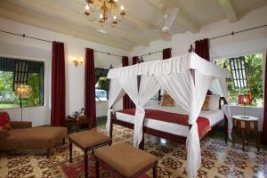 a hotel room with a canopy canopy on the ceiling at Siolim House in Siolim