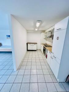 a kitchen with white appliances and a tile floor at Apartment mit 4 Betten in Karben