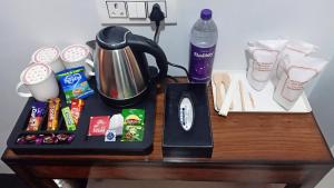 a table with a coffee pot and a alarm clock at Nirvana Stay & Gaming Zone in Bhadarwāh