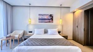 a bedroom with a bed and a table and a chair at Stella Beach Resort & Spa Makadi Bay - 24 HRS All Inclusive in Hurghada