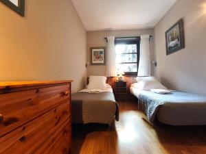 a small bedroom with two beds and a window at AC Apartaments Incles in Incles