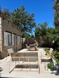 a patio with two chairs and a table and a table at Stone house Vert in Sveti Jakov