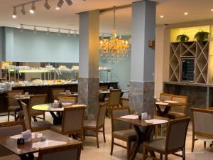 a restaurant with tables and chairs and a chandelier at Rede Andrade Itabuna in Itabuna +19 photos