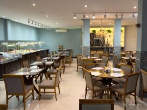 a restaurant with tables and chairs and a bar at Rede Andrade Itabuna in Itabuna