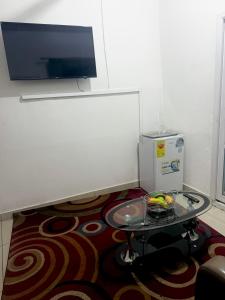 a living room with a table and a tv on the wall at O Ansah Plaza Lodge in Kumasi
