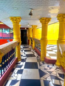 a room with yellow columns and a checkered floor at O Ansah Plaza Lodge in Kumasi +22 photos