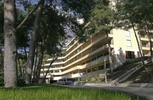 an apartment building with a road in front of it at Pine Resort by Residence in Strožanac +4 photos
