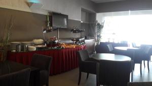 a restaurant with a red table with food on it at Kosma Business Hotel in Kuantan
