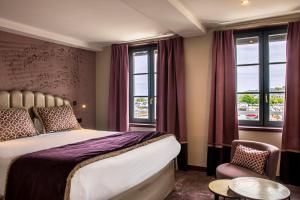a hotel room with a bed and windows at Best Western Le Cheval Blanc -Vue sur le port-plein centre ville in Honfleur +80 photos