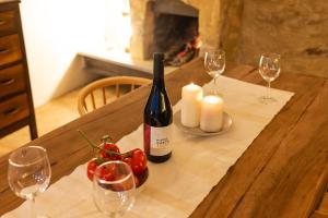 a table with a bottle of wine and two candles at Rocha Suites in Rocca Cilento