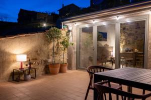 a patio with a table and chairs at night at Rocha Suites in Rocca Cilento