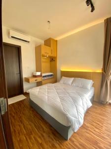 a bedroom with a large white bed and wooden floors at K Avenue by FRHome, 2 bedroom apartment within 5 min to KKIA airport in Kota Kinabalu +11 photos