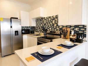 a kitchen with a counter with two plates and a refrigerator at The Nook in Kingston