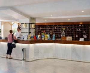 a woman standing at a counter in a hotel lobby at Benalbeach loft in Benalmádena