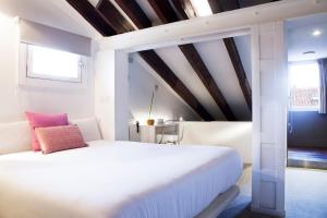 ein Schlafzimmer mit einem weißen Bett und einem rosa Kissen in der Unterkunft Artrip Hotel in Madrid