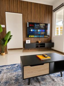 a living room with a coffee table and a tv at The Nook in Kingston