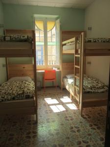 a bedroom with two bunk beds and a window at Corner Hostel in Sliema