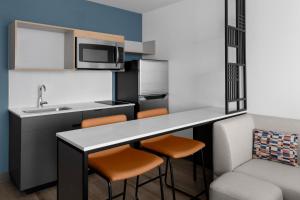 a small kitchen with a counter and stools at StudioRes by Marriott Denver Tech Center in Centennial +22 photos