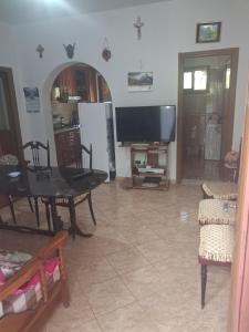 a living room with a television and a table and chairs at Apartament Dukat Albania in Dukat