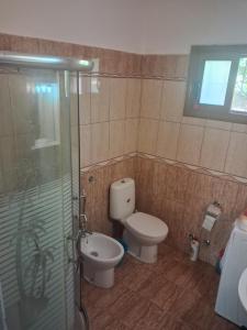 a bathroom with a toilet and a glass shower at Apartament Dukat Albania in Dukat +23 photos