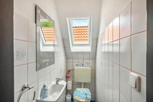 a small bathroom with a sink and a toilet at An't Fischerspad in Wangerland +38 photos