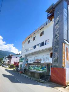 a white building on the side of a street at Nirvana Stay & Gaming Zone in Bhadarwāh