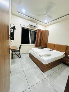 a bedroom with a bed and a desk and a window at Hotel Nakshatra in Guna +1 photo
