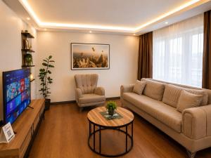 a living room with a couch and a tv at Lumiera Suites Hotel in Nilüfer