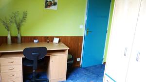 a room with a desk with a chair and a blue door at Peace Room in Veigné