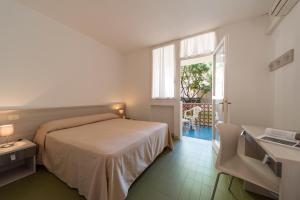ein Schlafzimmer mit Bett, Schreibtisch und Fenster in der Unterkunft Hotel Marina 2 in Marina di Campo + 51 Fotos