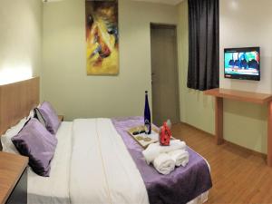 Postel nebo postele na pokoji v ubytování Royale Hotel Batu Gajah