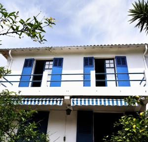 a white house with blue shutters and a balcony at Chambre privée, proche Croisette in Cannes