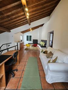 a living room with a white couch and a desk at Casa da Uva-Mosteiros Vineyards House-Heated swimming-pool in Mosteiros