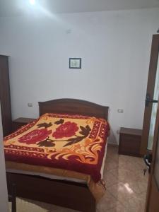 a bed in a room with a blanket on it at Apartament Dukat Albania in Dukat