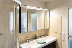 a bathroom with a sink and a large mirror at Ferienwohnung am Roten Schloss in Glashütte