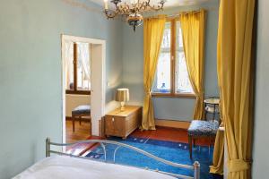 a bedroom with a bed and a dresser and windows at Ferienwohnung am Roten Schloss in Glashütte