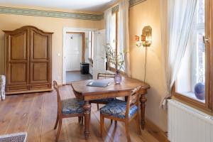 a dining room with a wooden table and chairs at Ferienwohnung am Roten Schloss in Glashütte +20 photos